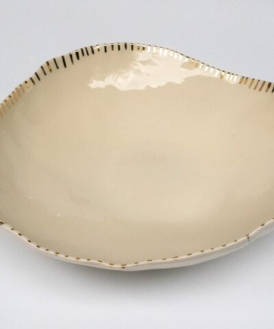 a serving bowl made from white porcelain with golden details