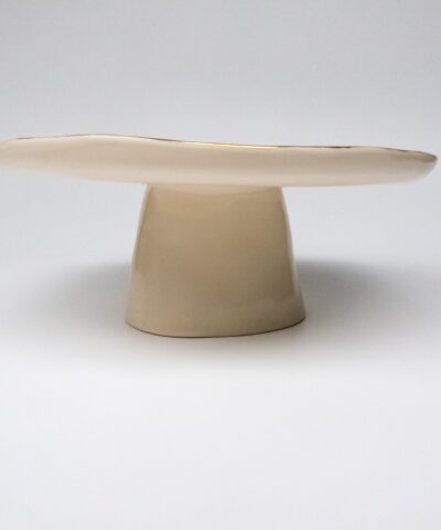 a cake stand made from white porcelain with golden details