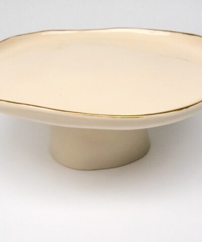 a cake stand made from white porcelain with golden details