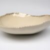 a serving bowl made from white porcelain with golden details
