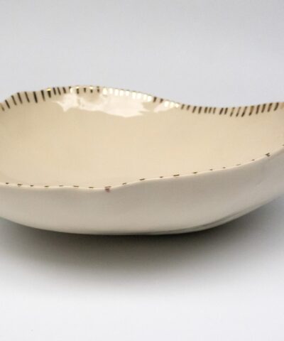 a serving bowl made from white porcelain with golden details