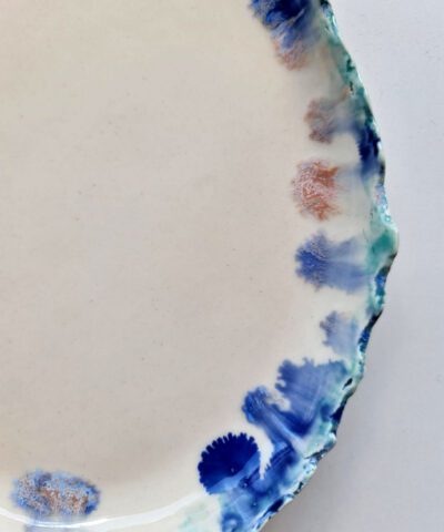 a unique plate with blue running glazes