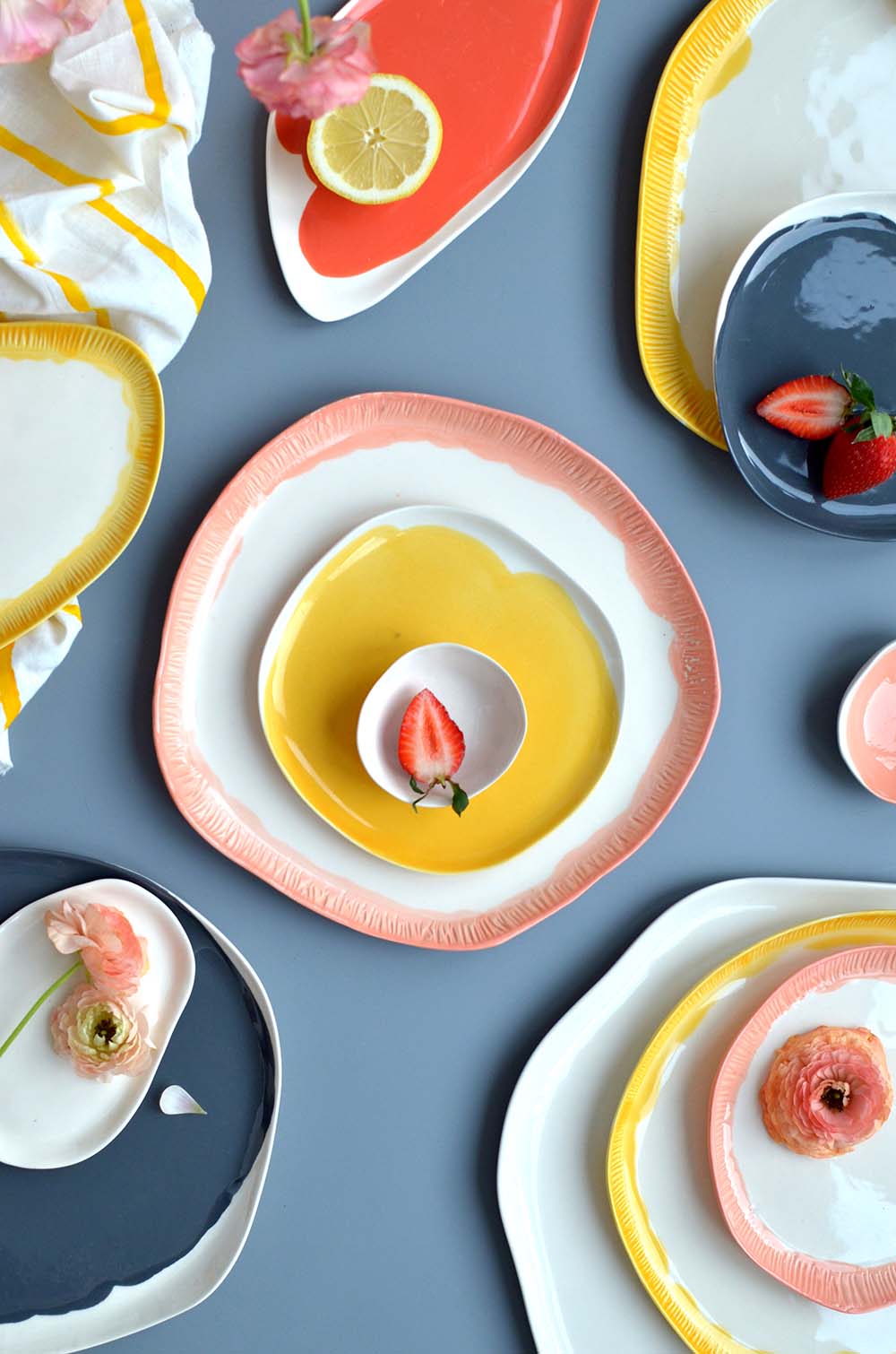 handmade luxury dinnerware in yellow, soft pink and grey. organic forms, styled
